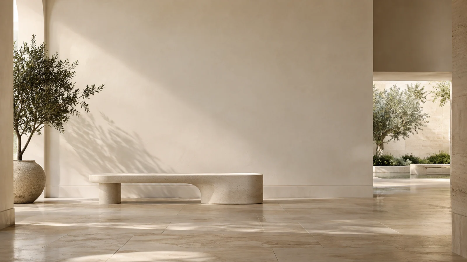A quiet architectural interior with a glimpse of a garden beyond the far opening