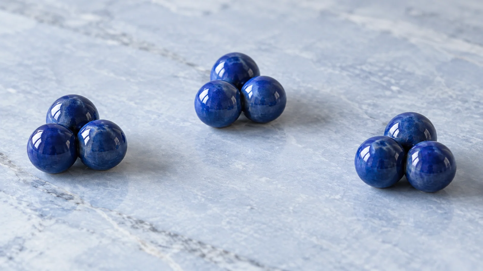 Identical blue ceramic spheres form three clearly separated groups through proximity.